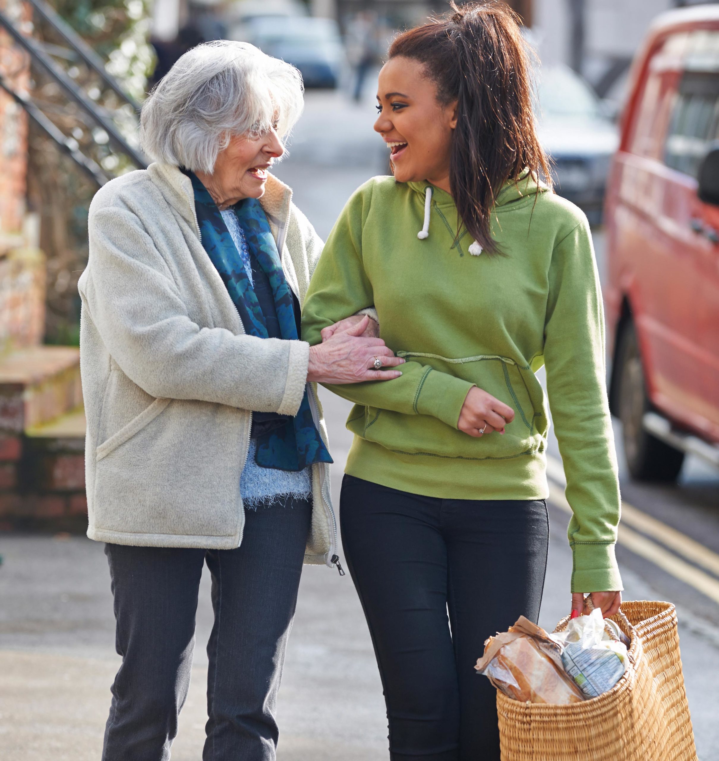 a young woman helping an elderly woman with groceries